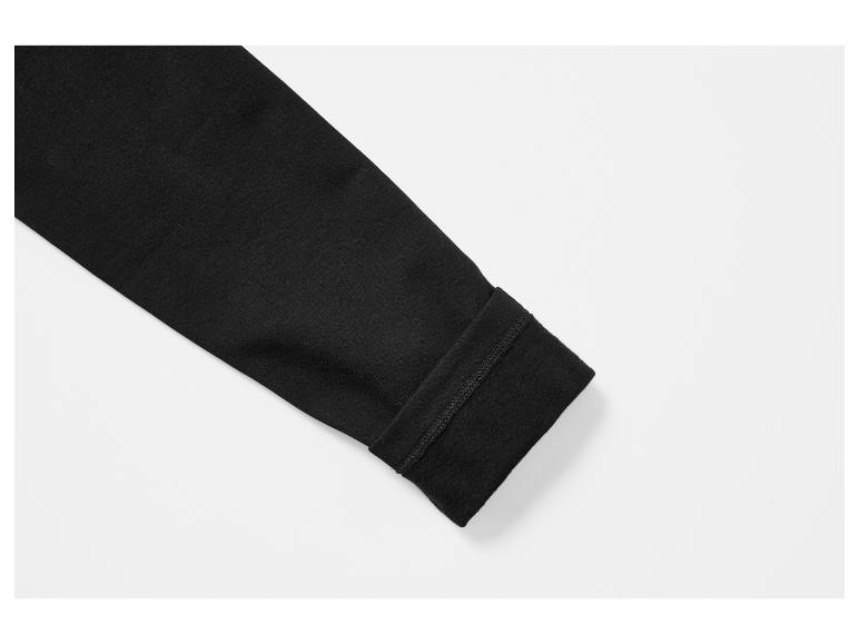 Gros plan d'une chemise noire à manches longues avec doublure polaire au poignet.