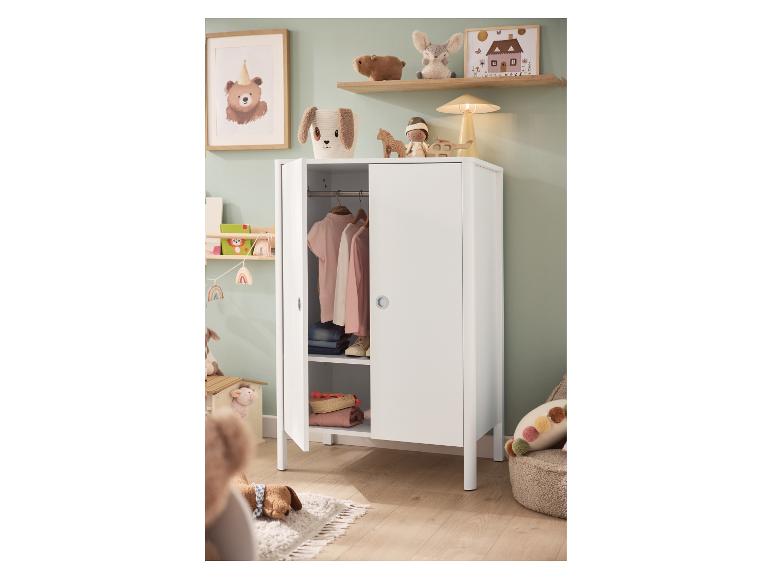 Armoire blanche pour enfant avec vêtements et jouets dans une chambre d'enfant décorée avec douceur.