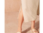Robe beige avec fente sur le côté et sandales beige à lanières tressées.