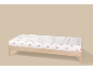 Drap-housse blanc à motif de nœuds rouges sur un lit en bois.
