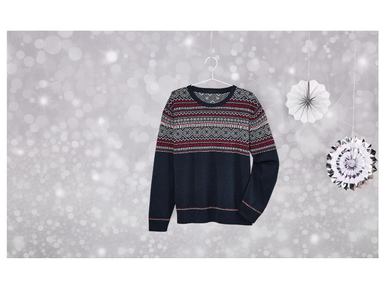 Un pull bleu marine à motifs scandinaves sur un fond argenté.