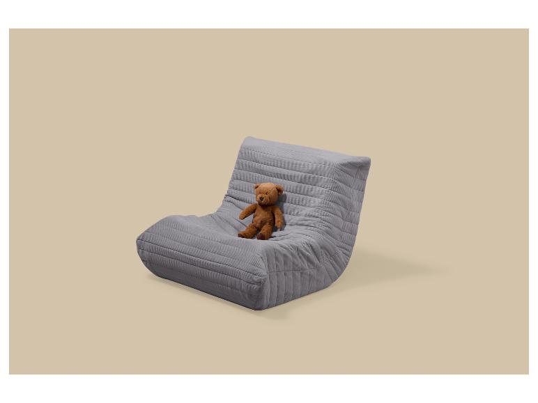 Fauteuil de sol gris avec un ours en peluche marron assis dessus.
