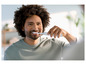 Un homme se brosse les dents avec une brosse à dents électrique.