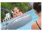 Garçon dans un requin gonflable tire avec un pistolet à eau dans la piscine.