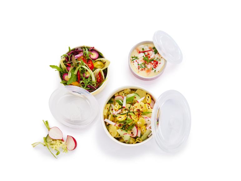Deux salades, l'une avec des pommes de terre et l'autre avec divers légumes, dans des récipients avec des couvercles
