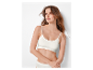 Modèle portant un soutien-gorge et des sous-vêtements blancs Sloggi.