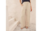 Pantalon beige à jambes larges et sandales en cuir.