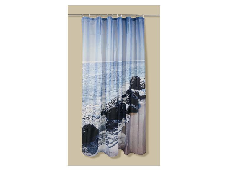 Rideau de douche avec motif marin, vagues s'écrasant sur des rochers sombres sur une plage de sable.