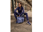 Femme en tenue de sport violette assise avec un sac de fitness et un tapis.