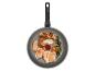 Une poêle Tefal avec du poulet, des pommes de terre et des asperges rôtis.