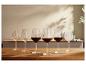 Six verres à vin sur une table en bois.