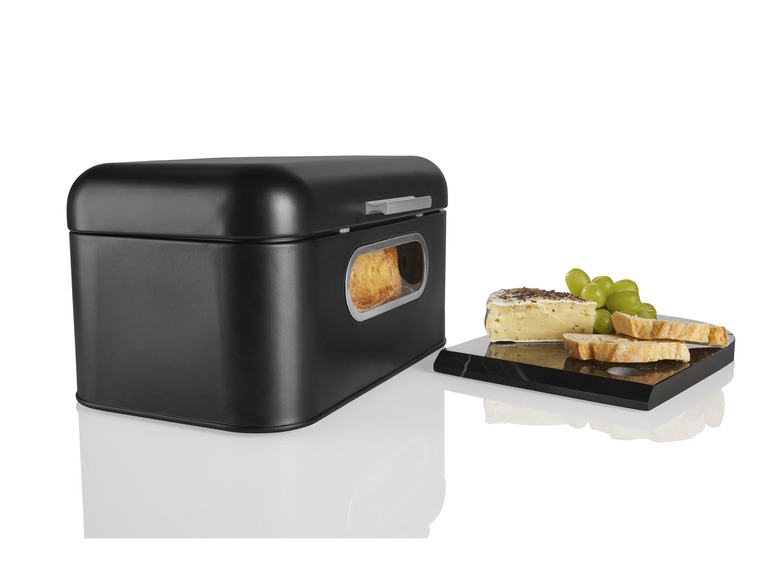 Une boîte à pain noire avec une fenêtre en verre et un plateau de service avec du fromage et du pain.