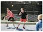 Joueurs de pickleball utilisant des raquettes sur un terrain.