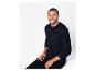 Un homme portant un pull et un pantalon noirs.
