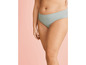 Une femme porte le bas d'un bikini vert clair.