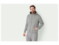 Un homme portant un sweat à capuche et un pantalon de survêtement gris.