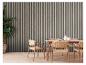 Coin repas avec mur à lattes en bois, chaises tressées et grande plante.