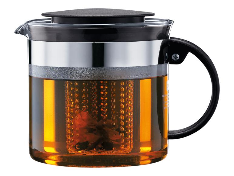 Théière en verre avec infuseur, remplie de thé ambré.