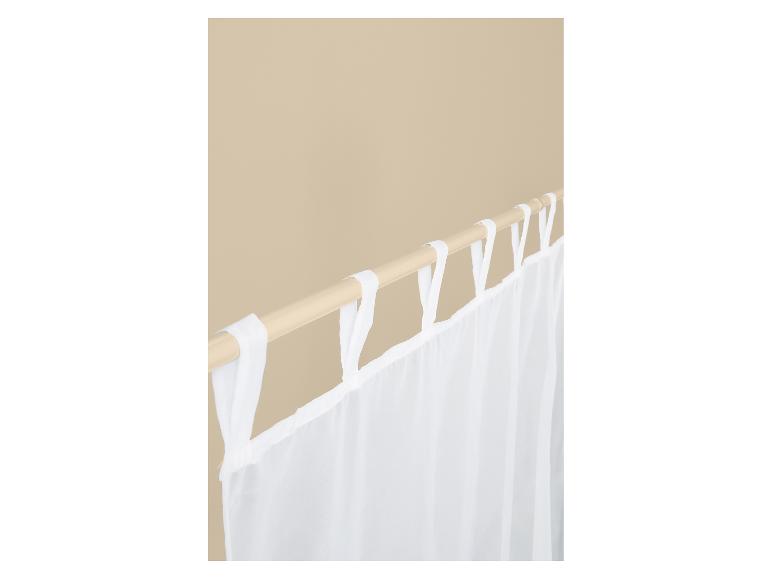 Rideaux blancs transparents à nouettes sur une tringle en bois.