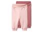 Deux pantalons de bébé rose clair et rose foncé.