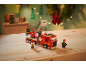 Camion de pompiers en jouet avec des figurines de pompiers sur une table en bois.