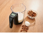 Pichet doseur avec balance numérique affichant 644 ml, à côté d'amandes et d'un œuf.