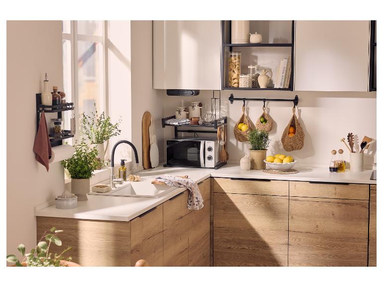 Cuisine moderne avec armoires en bois, plan de travail blanc, micro-ondes et étagères ouvertes.