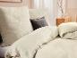 Parure de lit en mousseline de coton beige clair : draps, taies d'oreiller.