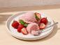 Boules de glace à la fraise avec des fraises fraîches et de la menthe sur une assiette blanche