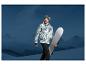 Un homme avec une veste de snowboard et des lunettes tient une planche de snowboard devant des montagnes.