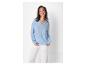 Chemisier bleu clair et pantalon blanc élégant pour femme.