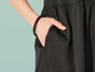 Une femme porte une robe noire avec un bracelet.