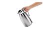 Une main tient une carafe isotherme en acier inoxydable.
