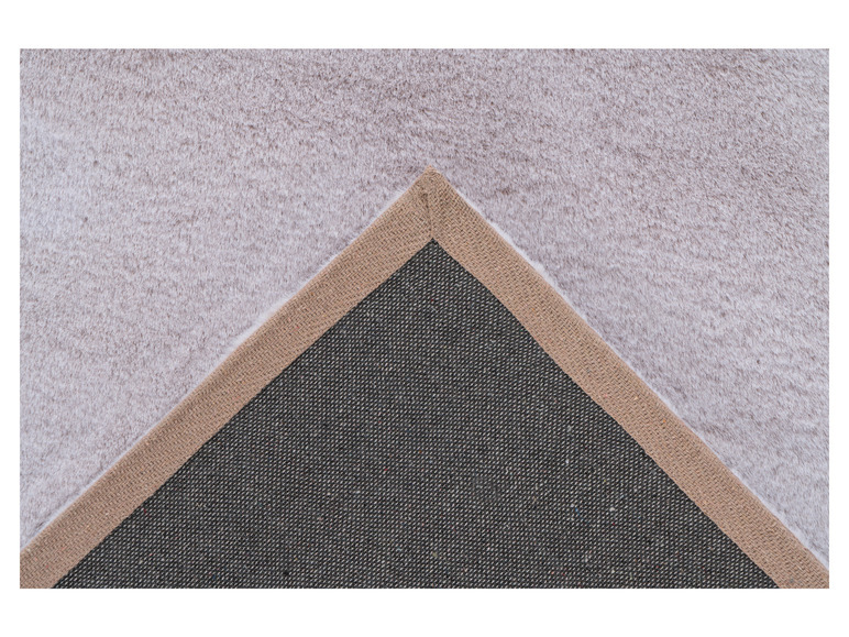 Détail d'un tapis blanc avec une bordure brune