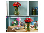 Des roses Lego dans un vase sur une table avec d'autres objets décoratifs.