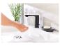 Robinet noir moderne, lavabo et porte-savon : ambiance salle de bain élégante.