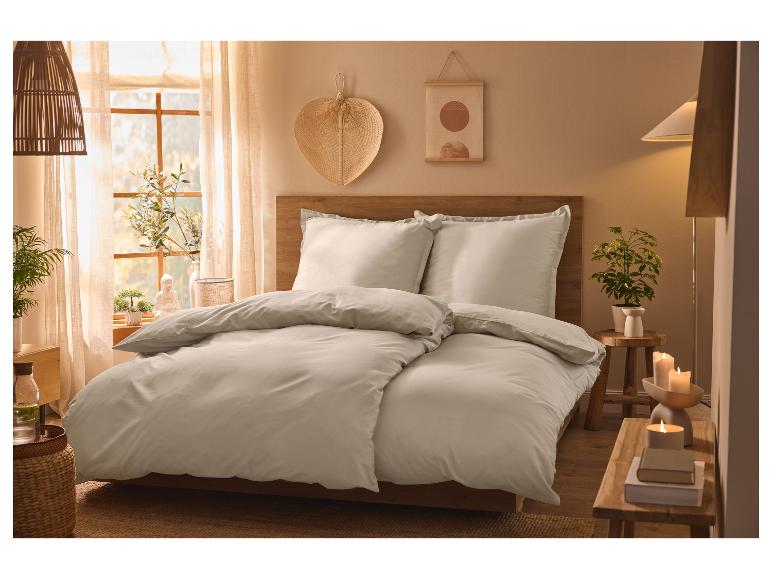 Lit douillet avec literie beige clair dans une chambre à coucher de style bohème.