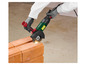 Une personne utilise une meuleuse Parkside pour couper des briques.