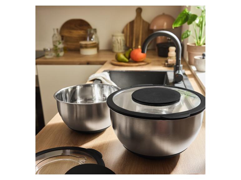 Deux bols en acier inoxydable avec couvercles sur un comptoir de cuisine.