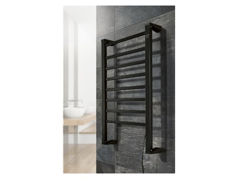 Sèche-serviettes noir monté sur un mur carrelé foncé dans une salle de bain.