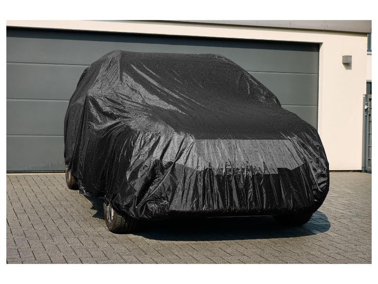 Housse de voiture noire avec des gouttelettes d'eau devant un garage.