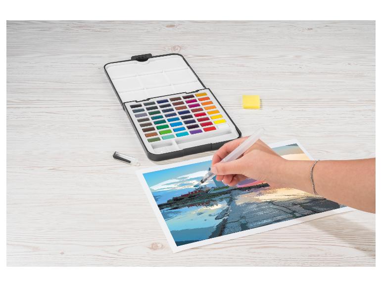 Une personne peint une scène côtière avec des aquarelles et un pinceau à réservoir d'eau.