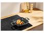 Poêle grill avec poulet grillé et légumes sur une plaque à induction