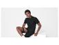 Un homme portant un polo et un short noirs.
