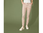 Pantalon beige à imprimé de feuilles blanches et baskets blanches.