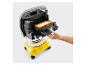 Homme retirant un filtre orange d'un aspirateur jaune et noir.
