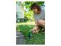 Femme coupant les bords de la pelouse avec un taille-herbe sans fil.