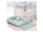 Lit bébé en bois blanc à roulettes et nid bébé vert menthe avec jouets ours.