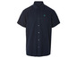 Une chemise bleu marine à manches courtes avec un petit logo.