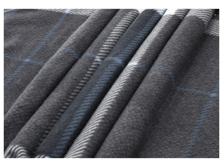 Gros plan d'une couverture douce à carreaux gris et bleus